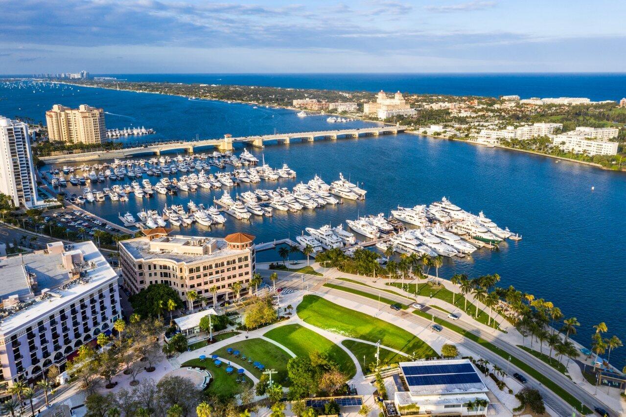 Aerial view of the West Palm Beach marina and waterfront park along Flagler Drive, with the Intracoastal Waterway, a bridge to Palm Beach and the Atlantic beyond